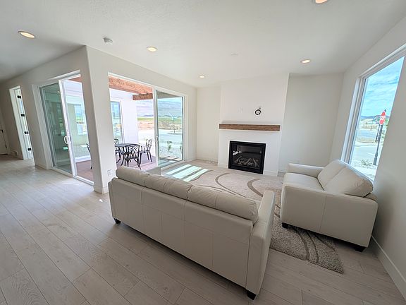 Bright living room with white sofas, fireplace, and large windows offers an airy retreat for the mod