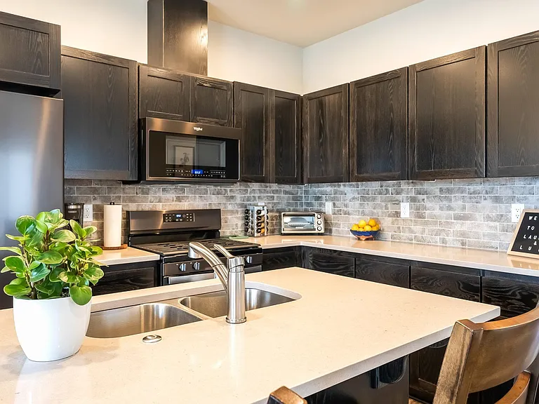 Kitchen with KitchenAid appliances, counter seating on island, toaster oven and coffee maker.