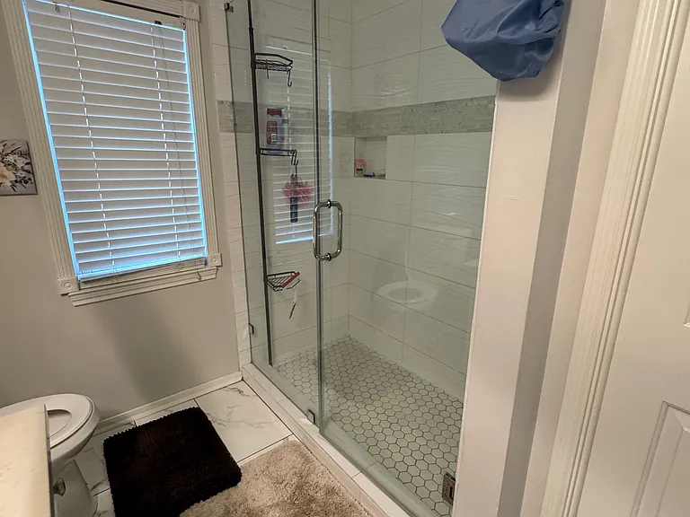 2nd bathroom with new tile floor and new frameless walk-in shower