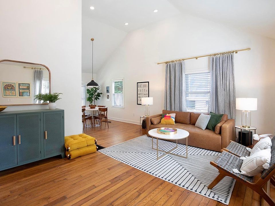 Living room with vaulted ceilings leading to dining area