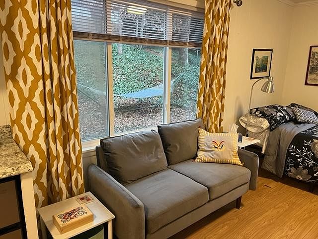 View of picture window showing private wooded backyard and hammock.