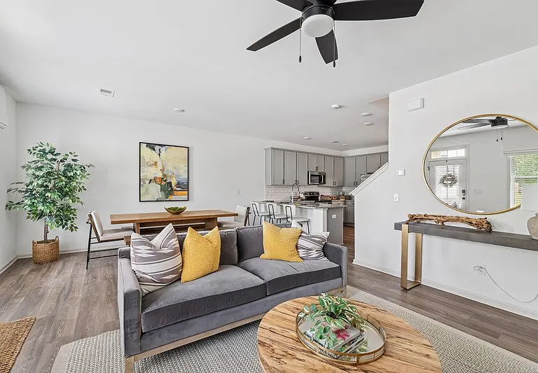 Living room with open view to kitchen and stairwell.