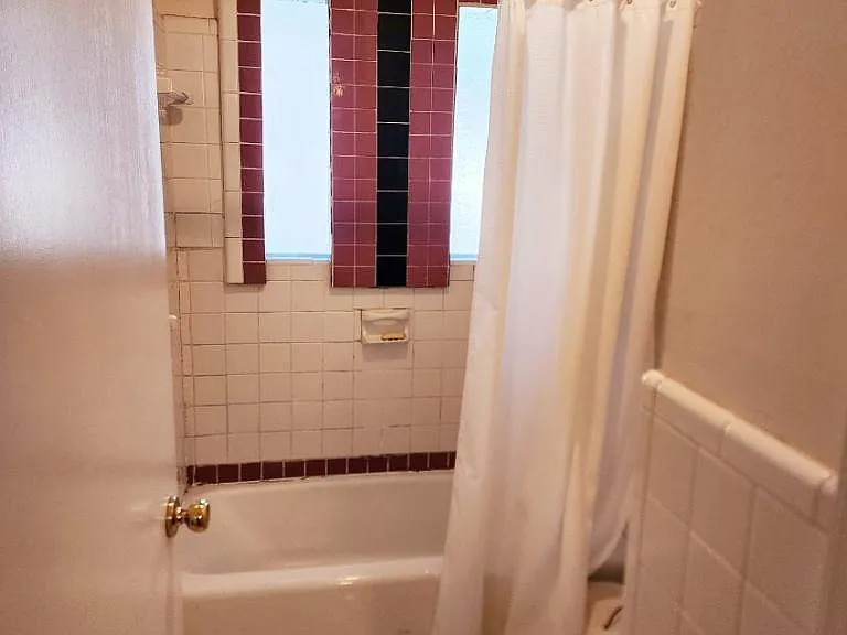 Bathtub and toilet separated from bathroom sink. this is an old picture, the tile and tub have been replaced.