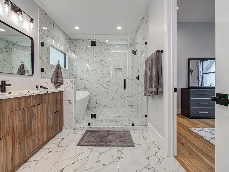 Spacious en-suite bathroom featuring a double vanity, walk-in shower, and elegant freestanding soaking tub_perfect for unwinding and relaxing after a long day.