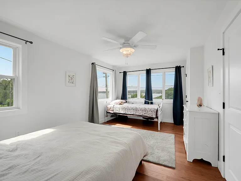 Primary Bedroom with a queen bed and twin bed, bureau and closet. There is a back door egress also