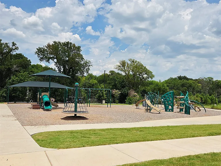 Community playground featuring multiple play structures on a wood chip surface