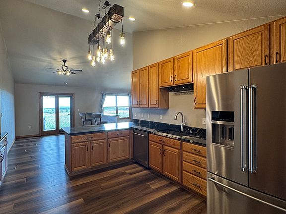 Spacious kitchen with all stainless appliances and a double oven with rustic features in the lighting.