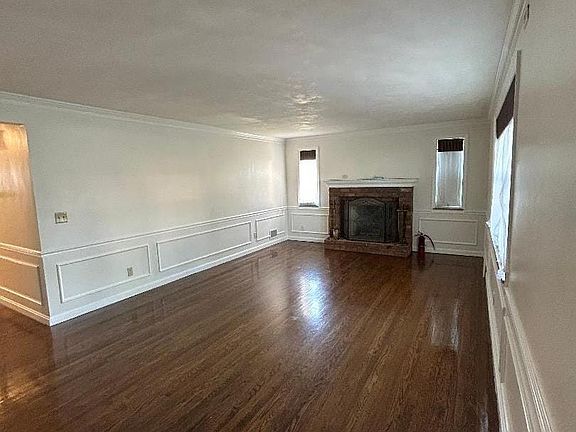 The living room is spacious and has lots of natural window light, hardwood flooring and room for your largest furniture