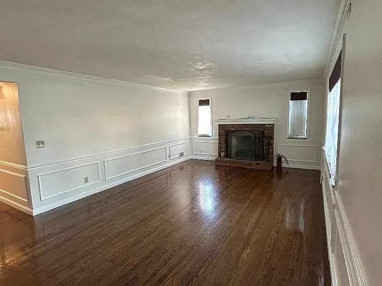 The living room is spacious and has lots of natural window light, hardwood flooring and room for your largest furniture