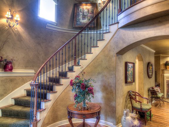Upon entering the home, you are greeted by a dramatic spiraling staircase.