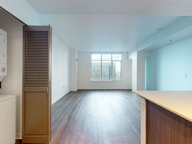 Apartment dining and living room with wood-style flooring.