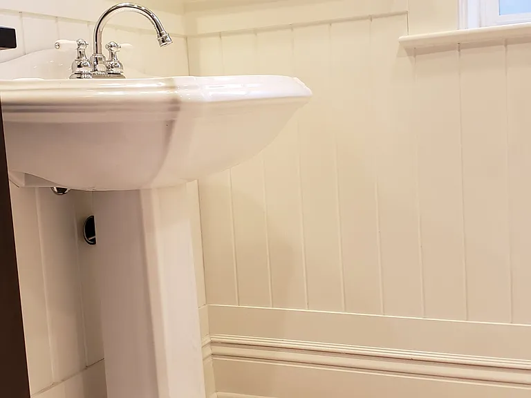 Marble bathroom floors with a pedestal sink.