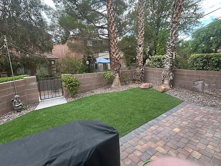 Private front yard artificial grass low maintenance landscaping bbq grill with flat top skillet included with rent.