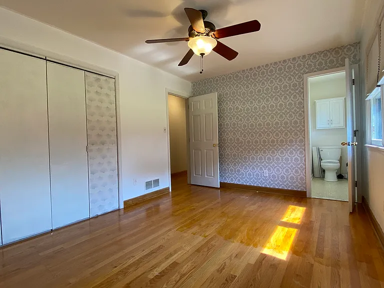 View of Primary Bedroom w/ Clg Fan & 1/2 Bath