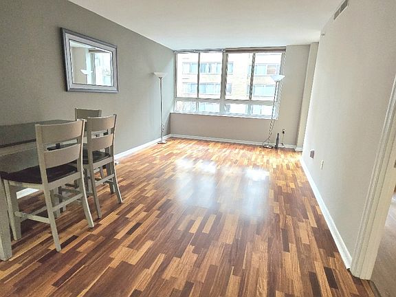 View of living/dining area from kitchen with bedroom door on right