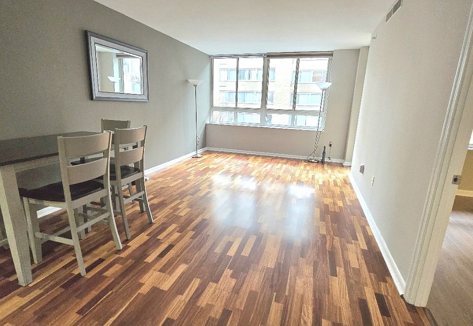 View of living/dining area from kitchen with bedroom door on right