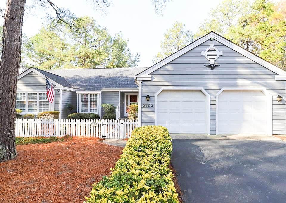 Front of home with 2 car garage, driveway and courtyard