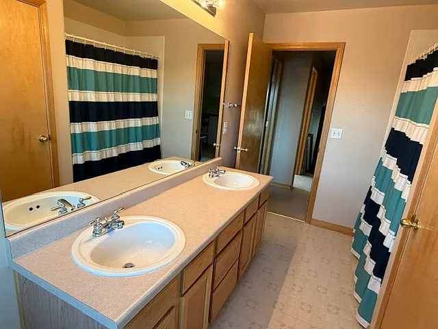 Shared bathroom with double sinks.