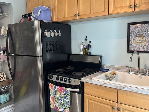 Stainless steel appliances in the kitchen. This unit has a full-size fridge.