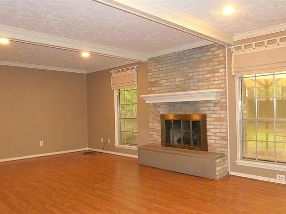 Spacious Family Room with beamed ceiling, low maintenance laminate floors, and gaslog fireplace.