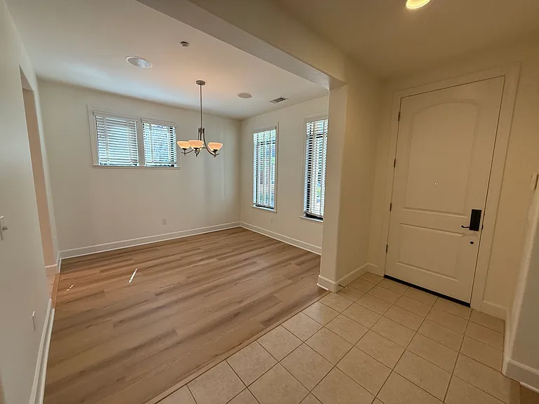 Bright, airy living room and dining room feature large windows, vinyl flooring throughout.