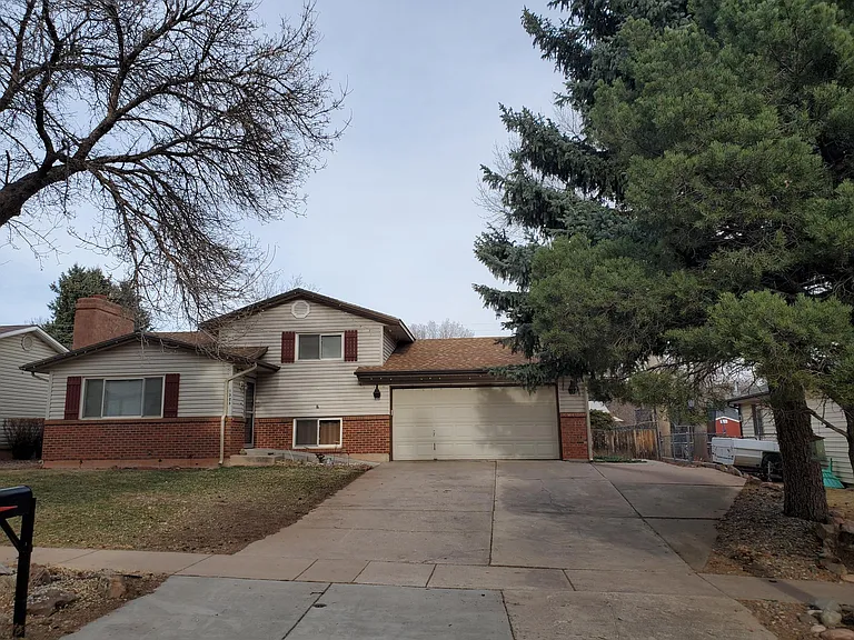 Front view of house showing attached two-car garage, large driveway and adjacent RV pad.
