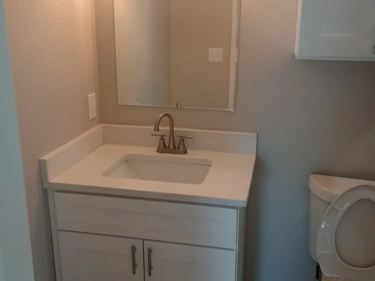 Upstairs unit Master Bath has single vanity, toilet with cabinet, and shower. All new!