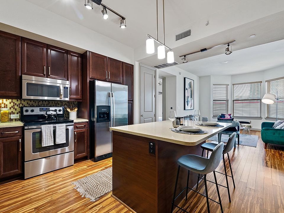Griffis Uptown apartment kitchen with wood style floors and stainless steel appliances.