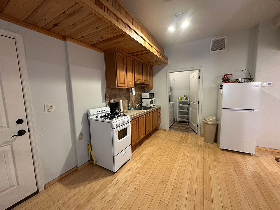 Double-sided locked door on left. (No entry on either side.) Gas stove/oven, kitchen area with pantry and washer/dryer, fridge.