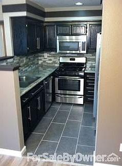 Kitchen
						:
						Custom wood cabinetry, tiled floor, and stainless steel appliances.