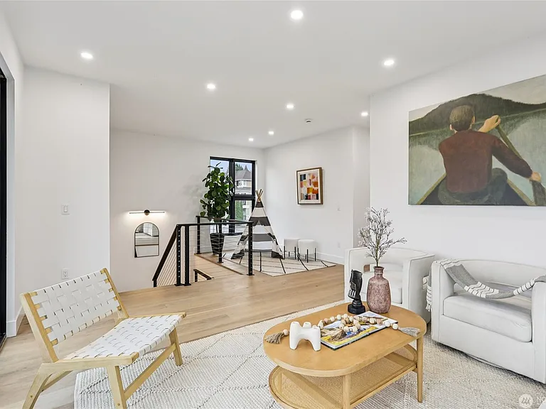 The upper level family room featuring an open-concept layout, and abundant natural light. The contemporary design offers the perfect blank canvas for relaxing or entertaining, with a cozy nook for a children's play area, home office, or reading corner.