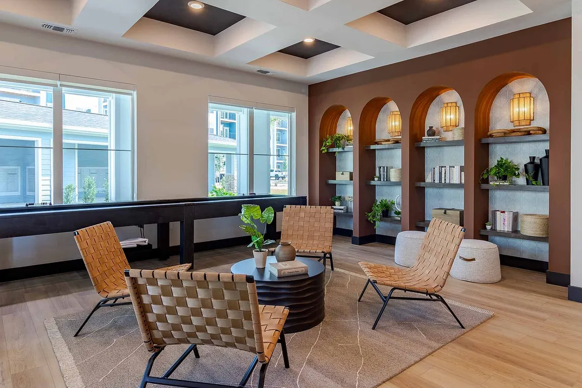 Relax in our stylish clubhouse nook, where curated arched shelving and woven seating create a warm, design-forward gathering space. Or if you're looking for a little more excitement, enjoy our shuffleboard table with friends.