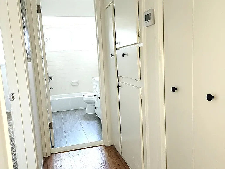 Hallway to bedroom and bathroom with storage