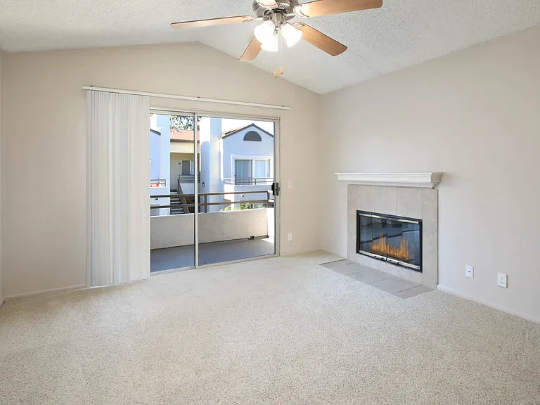 Carpeted Living Room with Fireplace and Balcony