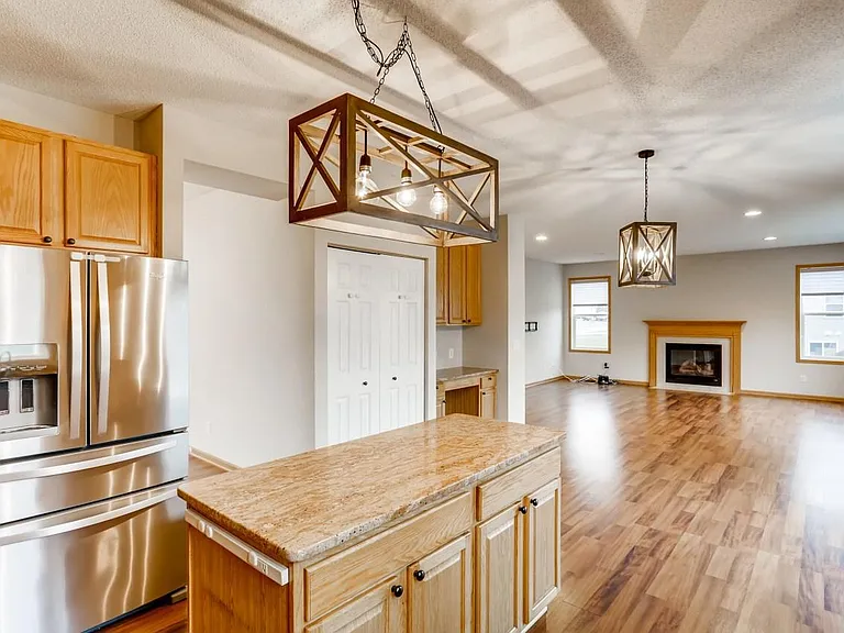 Kitchen with granite countertops and stainless steel appliances. Looking to family room.