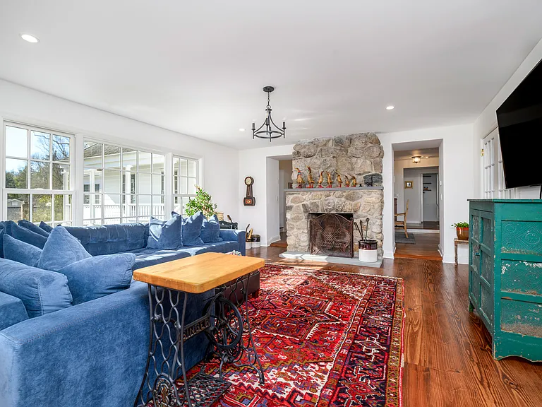 Large living room with stone fireplace and abundant natural light from the over sized windows