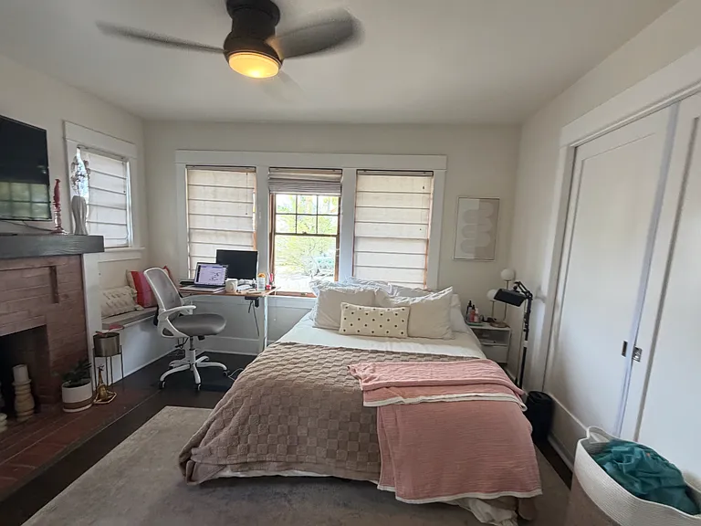 Hardwood floors, windows with custom shades (all open), fireplace, ceiling fan and closet. There's an additional hallway closet available for private use.