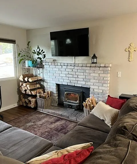 Wood-burning fireplace in living room with TV.