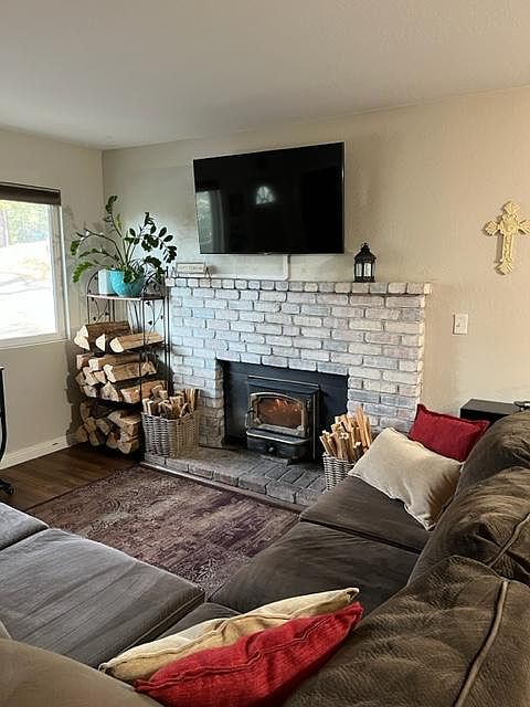 Wood-burning fireplace in living room with TV.