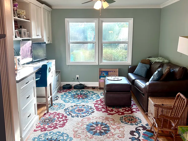 Home office with built desk and cabinets.