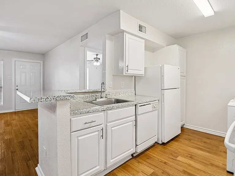 Bright and modern kitchen with sleek countertops, white cabinetry, and wood-style flooring providing an inviting atmosphere. Bright and modern kitchen with sleek countertops, white cabinetry, and wood-style flooring providing an inviting atmosphere.