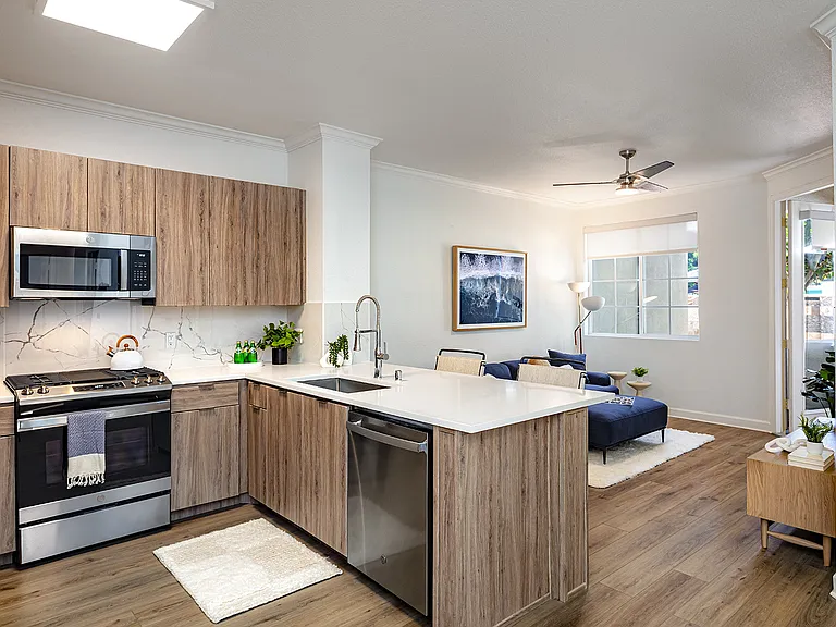 An open-concept living space with a kitchen featuring a breakfast bar, and a living area with a couch.