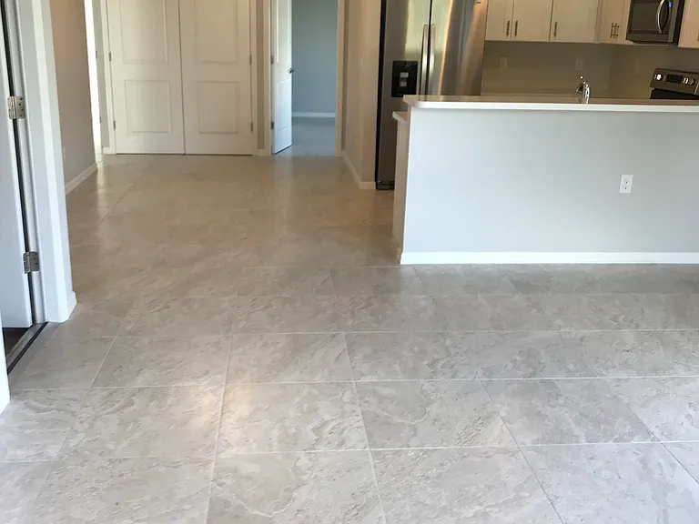 Discover the beauty of open-concept living. This expansive home features seamless tile flooring throughout, perfectly connecting your dining and kitchen areas for effortless flow and a bright, modern atmosphere throughout the entire space