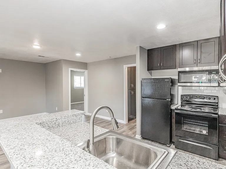 Enjoy cooking in stylish kitchens with dark cabinetry and granite-style counters at Chapel Creek Apartments.