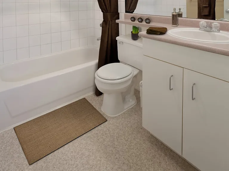 Classic Package I bath with laminate countertops, white cabinetry, and laminate flooring