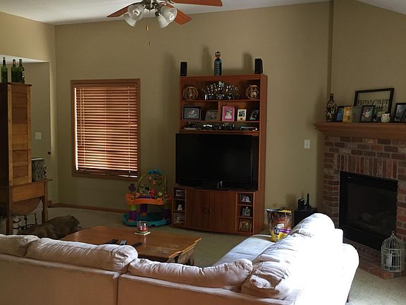 Upstairs Main Living Area from kitchen towards stairs, with fireplace on right, as well as doors to deck.