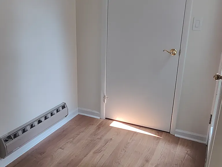 Area at the base of the stairs with one more closet.