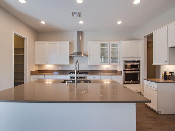 Open kitchen with white cabinet and big quartz counter top