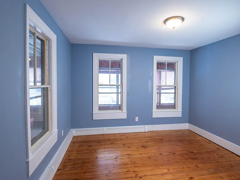 bedroom #1 featuring refinished pine floor and 3 huge windows