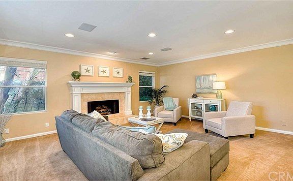 Living room with recessed lights, crown moldings and a fireplace